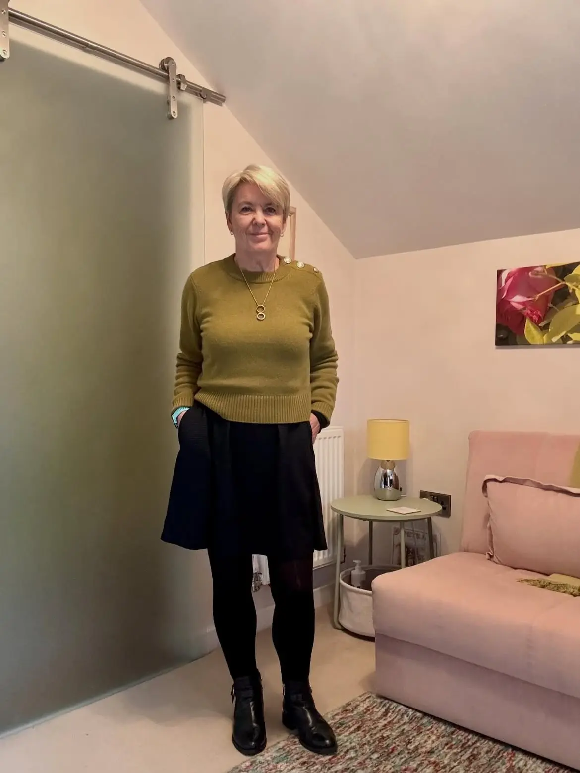 15 Cashmere Outfits for Women Over 40 That Feel Cozy and Polished 11 10. Olive Green Sweater With a Black Skirt, Tights, and Ankle Boots