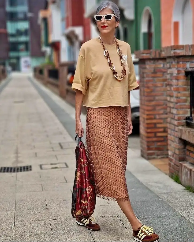 15 Chic Outfits for Women Over 40 You Can Copy This Week 2 Sweatshirt and Beaded Midi Skirt With Retro Sneakers