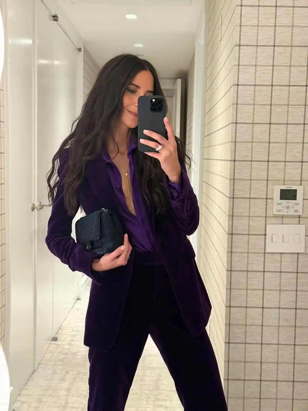 15 Velvet Outfits for Women Over 40 to Wear All Season 16 15. Deep Purple Velvet Suit With a Sequin Clutch