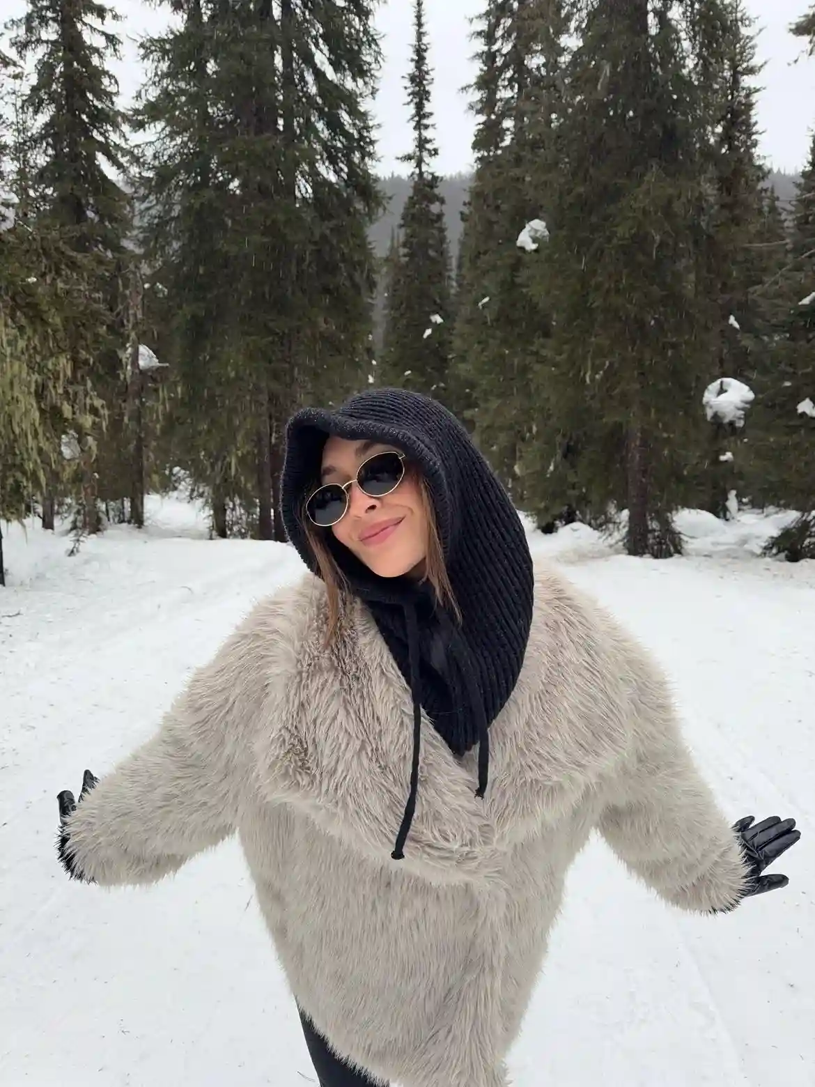 19 Winter Vacation Outfits Over 40 (Warm Getaways) 19 18. Gray Faux Fur Jacket With a Black Knit Hood