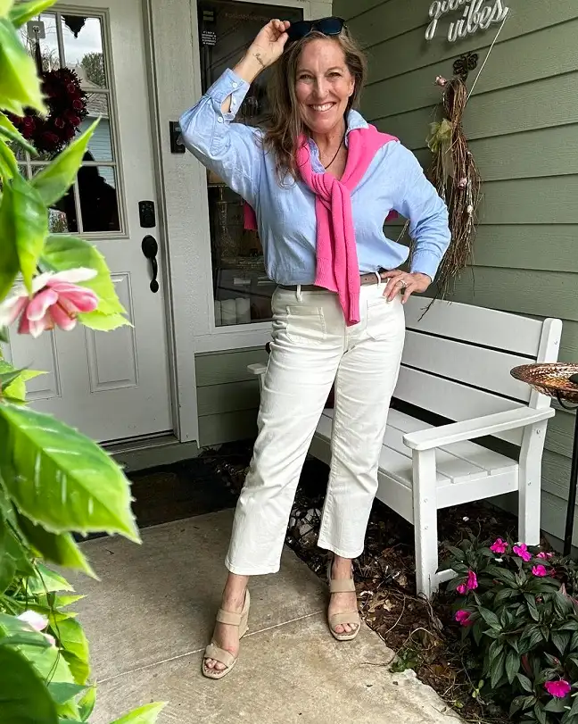 18 Spring Work Outfits for Women Over 40 That Feel Fresh, Not Fussy 18 Oxford Shirt With a Pink Sweater Over the Shoulders