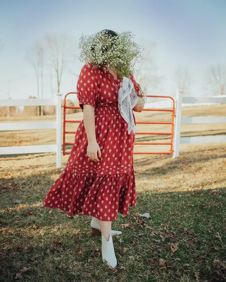 18 Boho Outfits for Women Over 40 (Not Costume-y) 13 Red Tiered Midi Dress with White Western Boots