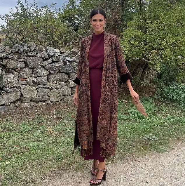 15 Winter Wedding Guest Outfits Over 40 That Handle the Cold 14 Burgundy Column Dress Under a Paisley Fringed Duster