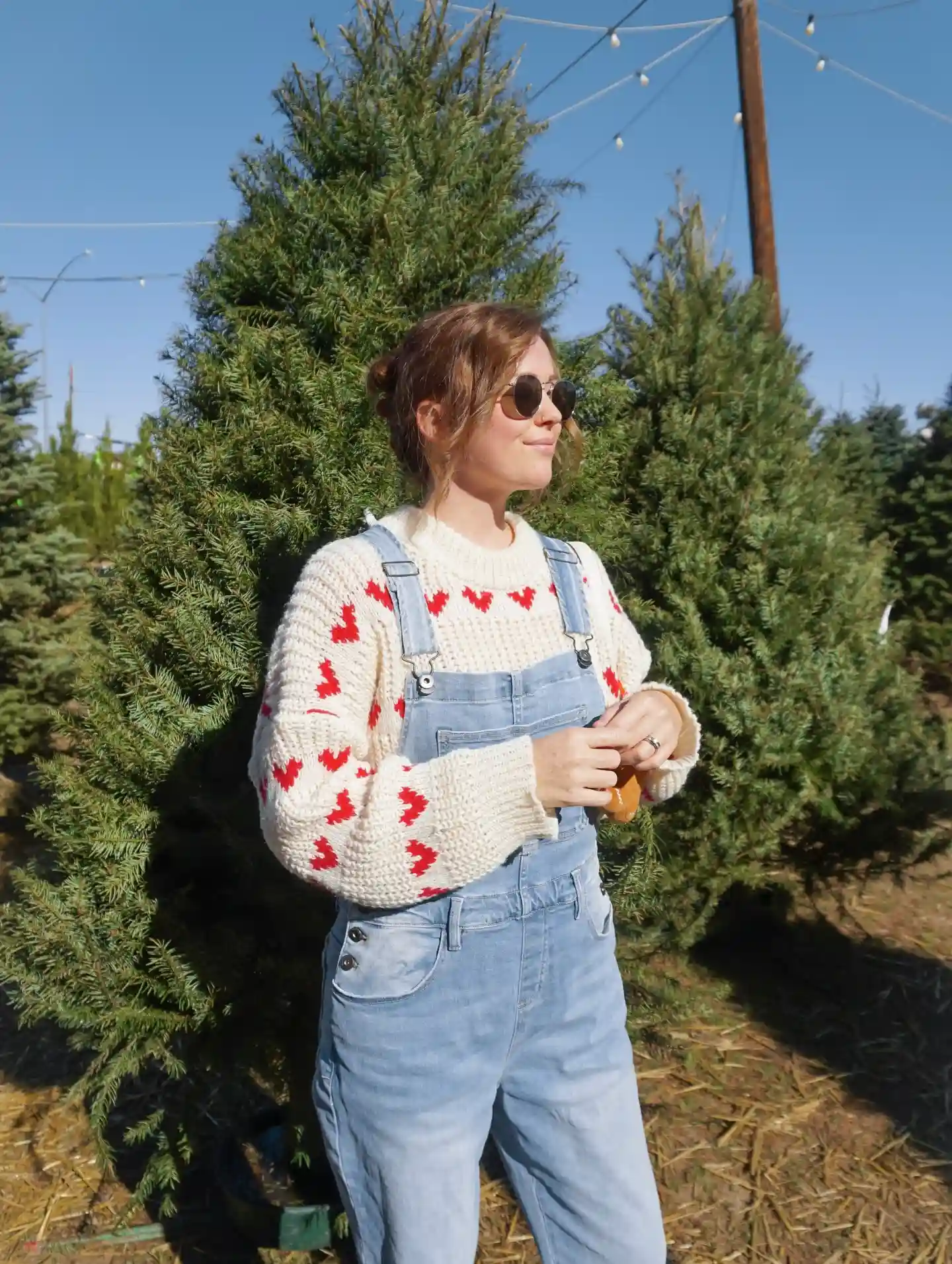 19 Winter Vacation Outfits Over 40 (Warm Getaways) 16 15. Heart Sweater and Denim Overalls for a Holiday Trip