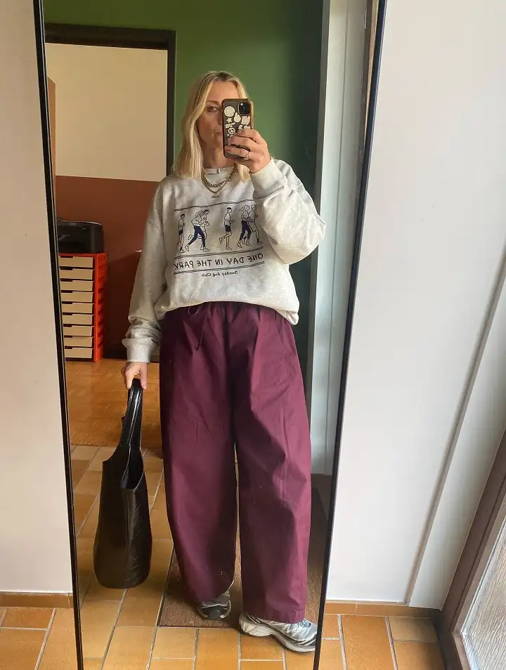 20 Work Outfits for Women Over 40 That Look Effortlessly Polished 16 Graphic Sweatshirt with Burgundy Barrel Trousers