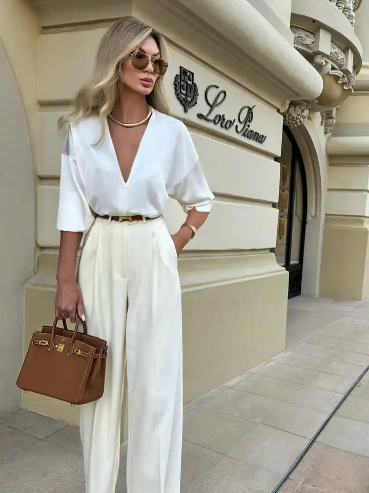 17 Old Money Outfits for Women Over 40 That Look Rich Without Trying 12 A Silky White V Neck Blouse With Cream Pleated Trousers