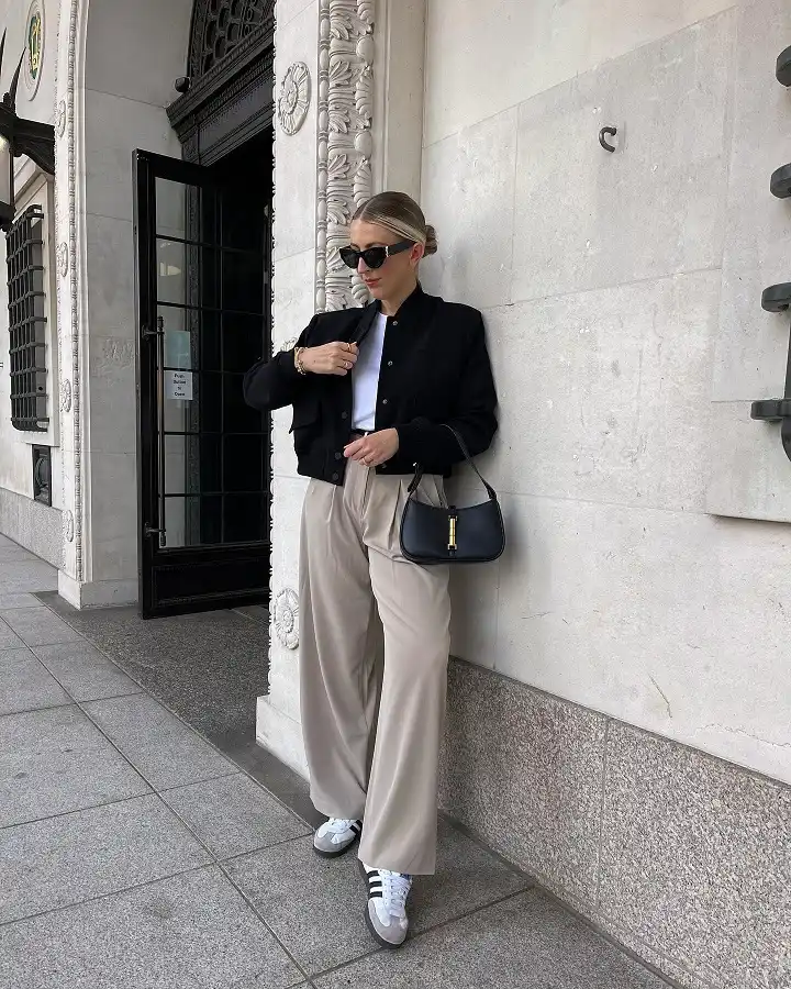 16 Spring Transitional Outfits Over 40 (Winter-to-Spring) 3 Black Bomber Jacket Over Wide Beige Trousers