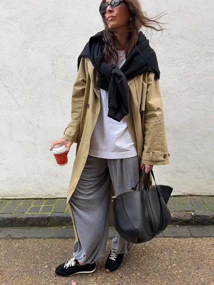 Khaki Trench, Gray Joggers, and a Sweatshirt Over the Shoulders