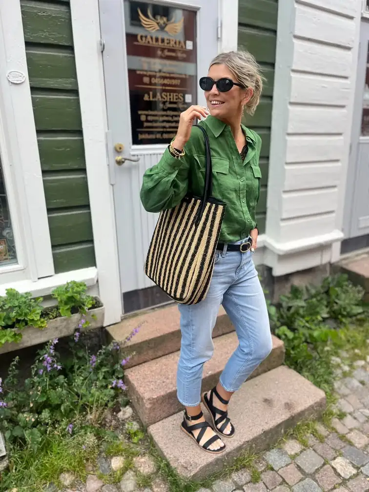 15 Chic Outfits for Women Over 40 You Can Copy This Week 15 Green Utility Shirt With Cropped Jeans and a Striped Tote