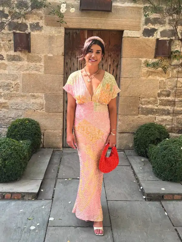 17 Fall Wedding Guest Dresses Over 40 That Look Expensive 11 10. Sherbet Print Bias Maxi With a Coral Bag