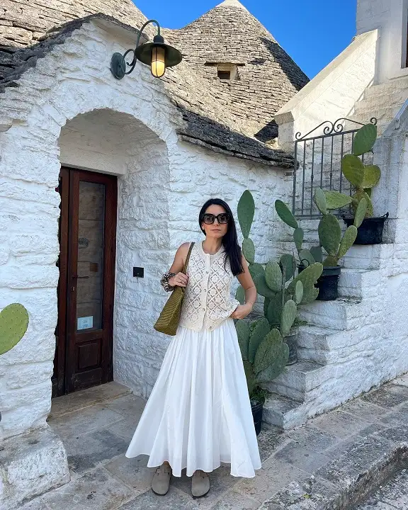 17 Italy Vacation Outfits for Women Over 40 That Look Effortlessly Chic 18 Cream Crochet Vest with a White Maxi Skirt