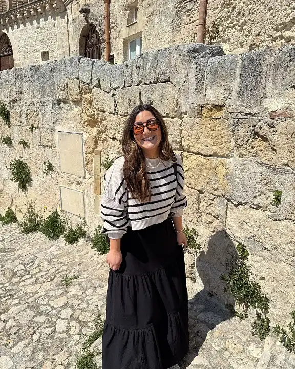 15 European Vacation Outfits for Women Over 40 8 Striped Cropped Sweater with a Black Tiered Maxi Skirt