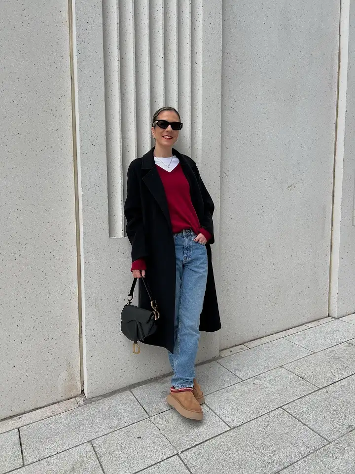 15 Chic Outfits for Women Over 40 You Can Copy This Week 13 Long Black Coat With a Red Sweater and Platform Slippers