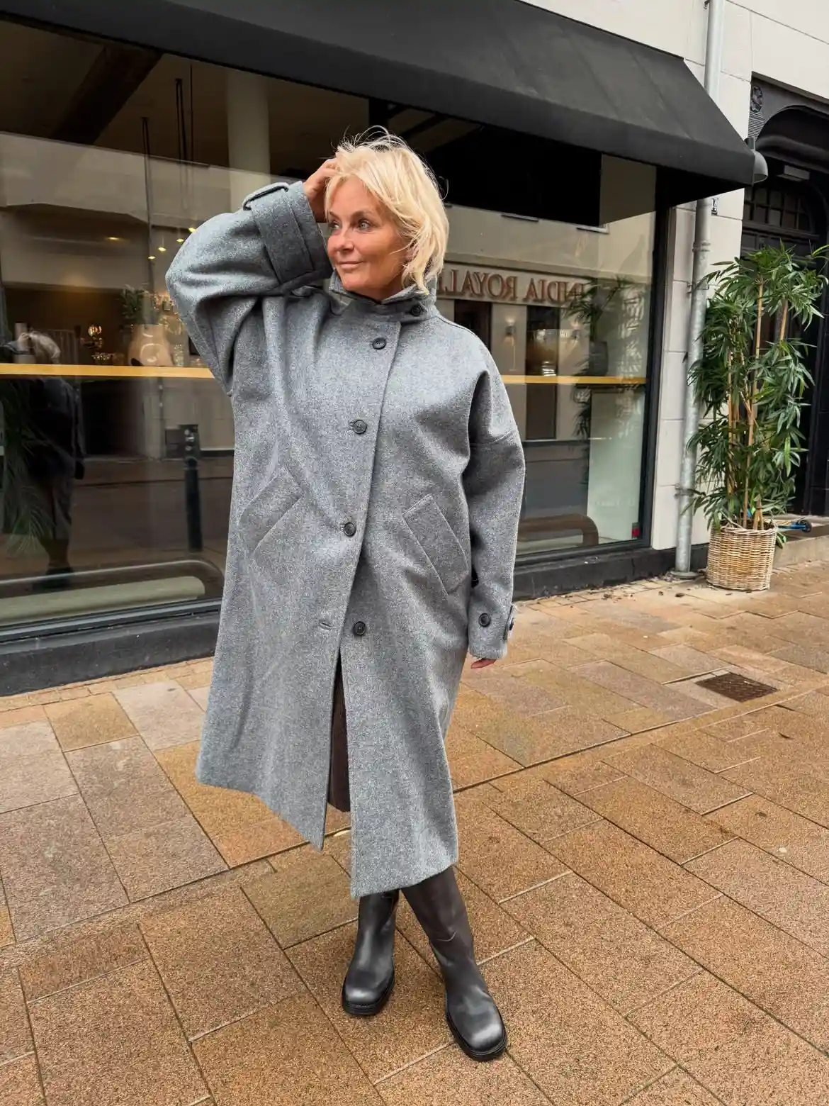 18 Wool Coat Outfits for Women Over 40 You Can Copy This Winter 13 12. Oversized Gray Wool Coat With a Stand Collar and Tall Black Boots