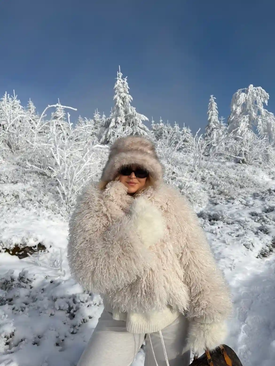 19 Winter Vacation Outfits Over 40 (Warm Getaways) 6 5. Fluffy Cream Jacket and Fur Hat for Snow Days
