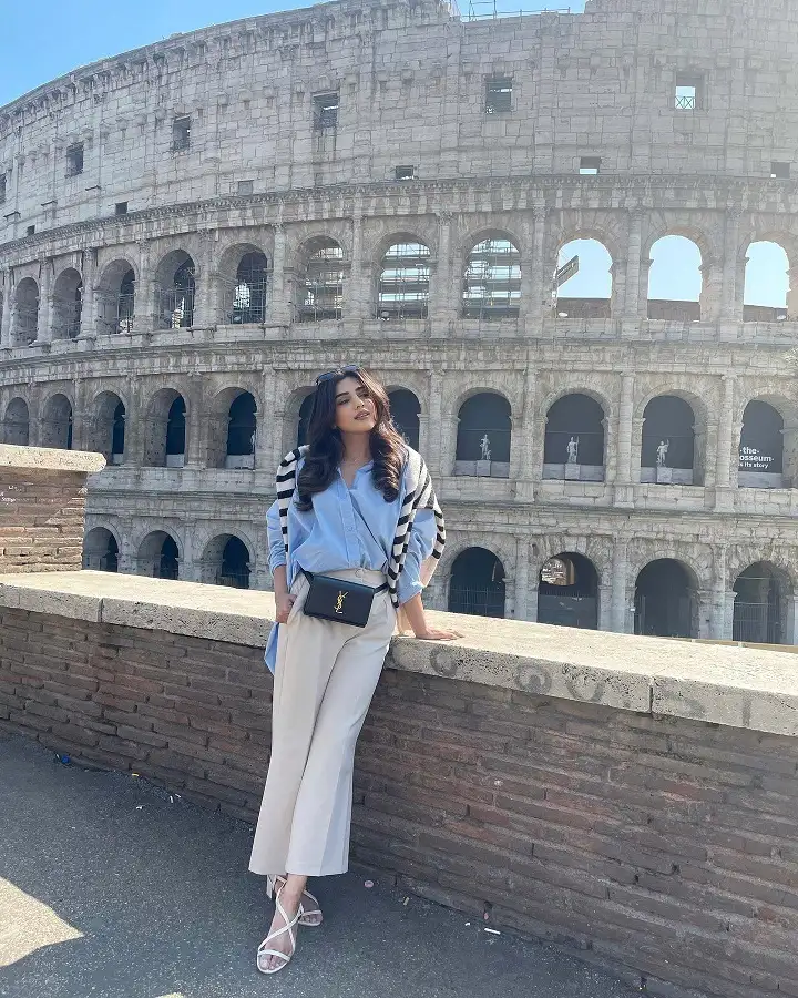 17 Italy Vacation Outfits for Women Over 40 That Look Effortlessly Chic 5 Blue Shirt, Cream Trousers, and a Striped Knit Drape