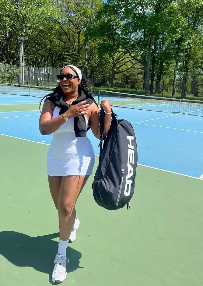 A Fitted White Tennis Dress With a Sweatshirt Tied at the Shoulders