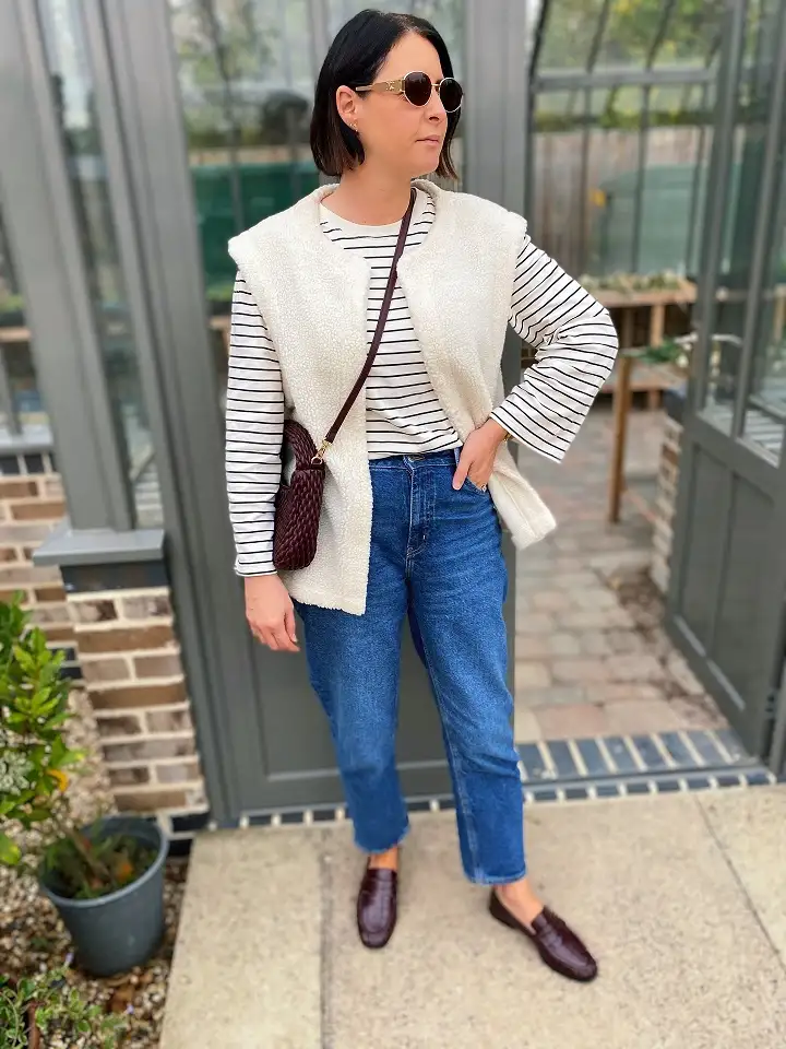 15 Chic Outfits for Women Over 40 You Can Copy This Week 12 Fleece Vest Over a Striped Tee and Straight Jeans
