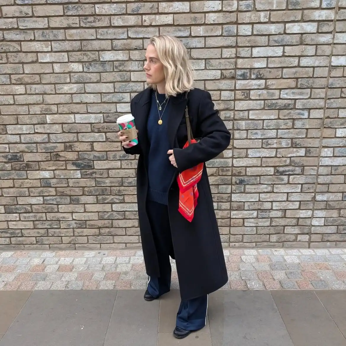 18 Wool Coat Outfits for Women Over 40 You Can Copy This Winter 17 16. Long Black Wool Coat With Navy Track Pants and a Red Scarf