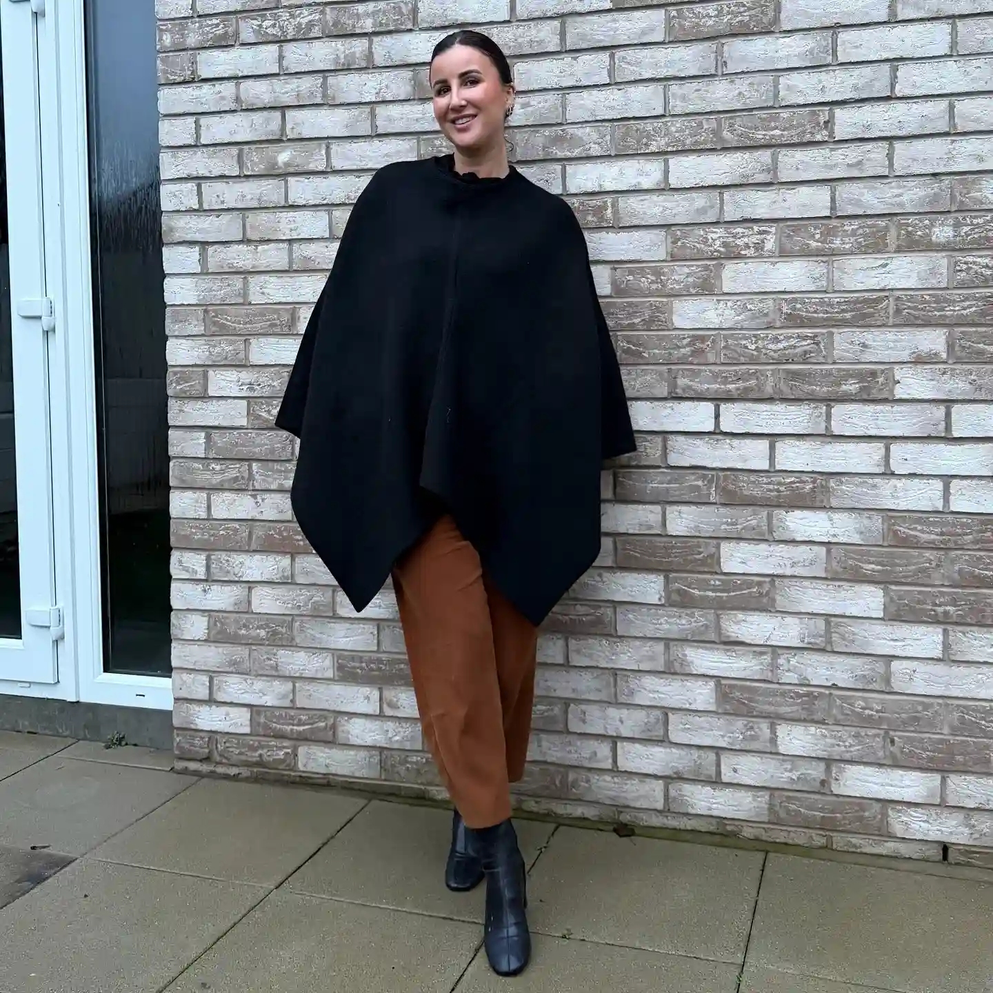 7. Black Poncho and Rust Trousers