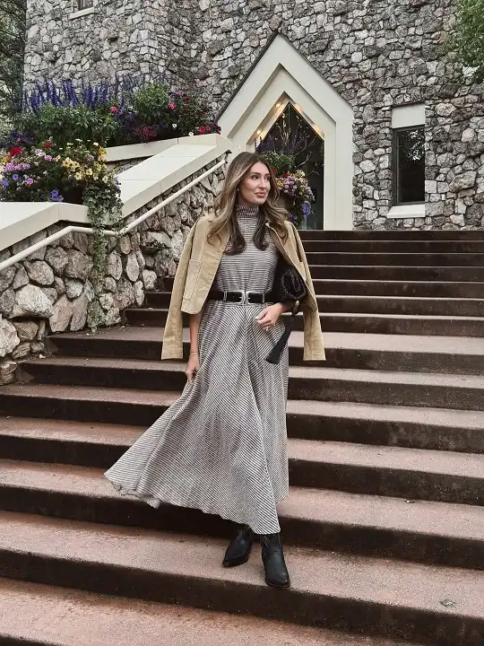 15 Winter Wedding Guest Outfits Over 40 That Handle the Cold 13 Striped Knit Turtleneck Maxi With a Camel Jacket